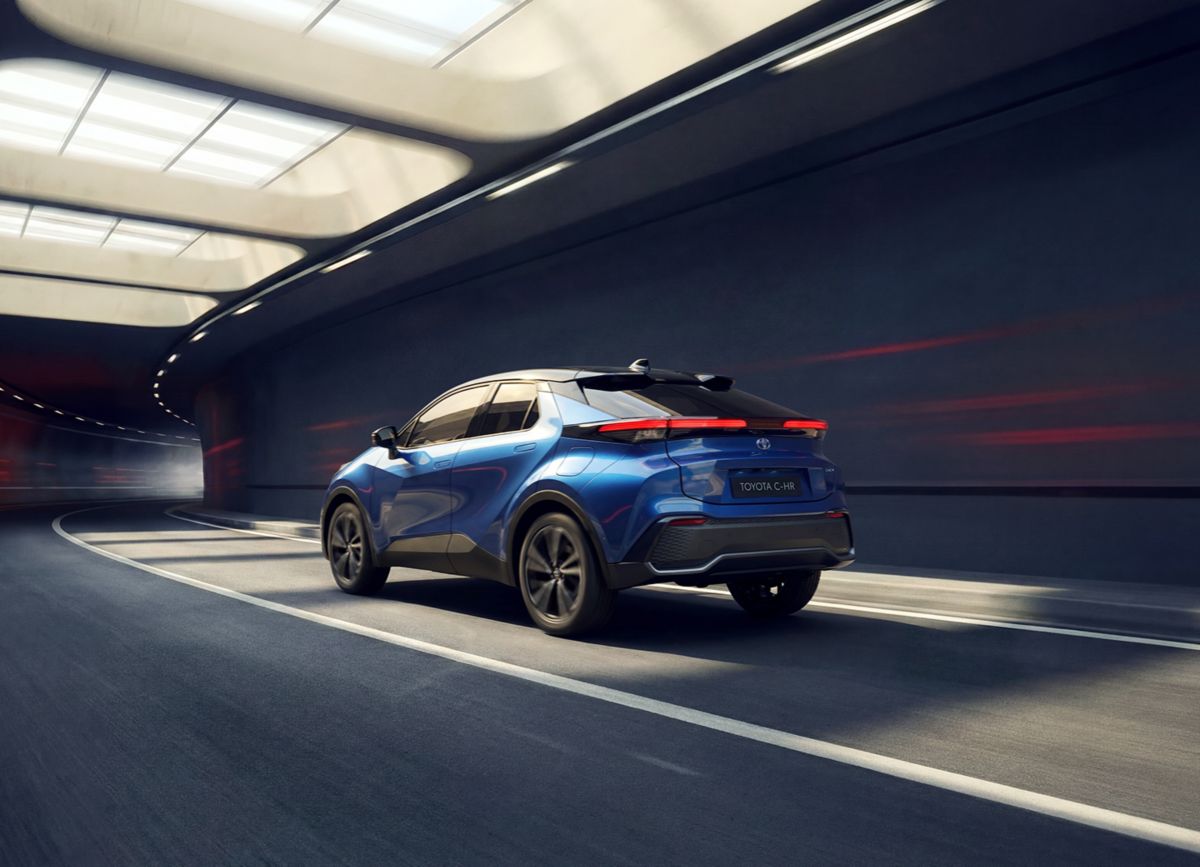 Blauer Toyota C-HR fährt in einem modernen, kurvigen Tunnel mit indirekter Deckenbeleuchtung